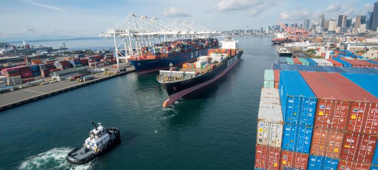 A tugboat pulling a container ship.